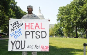 service member with ptsd sign at the capitol building